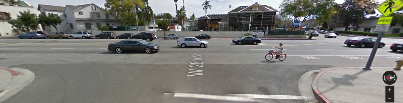 Google Street View of Cyclist riding the wrong way on Hoover at 28th. Moderate traffic in the background.